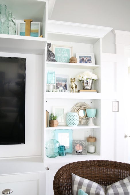 It can be a challenge to know how to decorate shelves, but this foolproof formula will teach you how to style shelves beautifully in no time! | #shelfie #shelfstyling #styledshelves #bookshelfstyling #livingroom #livingroomdecor #summerdecor #vignette Decorated Shelves, Coastal with Aqua, Mint, and White