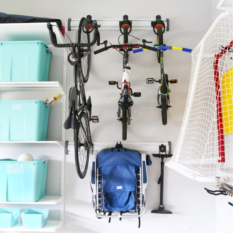 Bikes stored on a wall track system in an organized garage