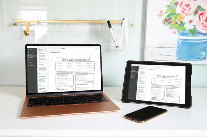 White desk with computer, iPad and iPhone sitting on it