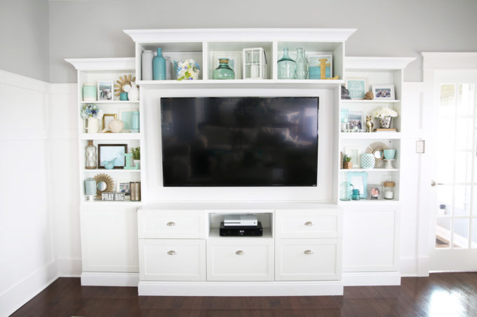 It can be a challenge to know how to decorate shelves, but this foolproof formula will teach you how to style shelves beautifully in no time! | #shelfie #shelfstyling #styledshelves #bookshelfstyling #livingroom #livingroomdecor #summerdecor #vignette Completed Styled Shelves with Aqua, White, and Neutral Shelf Decor