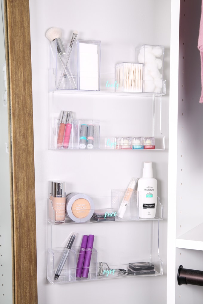 makeup organized in acrylic spice racks on the wall