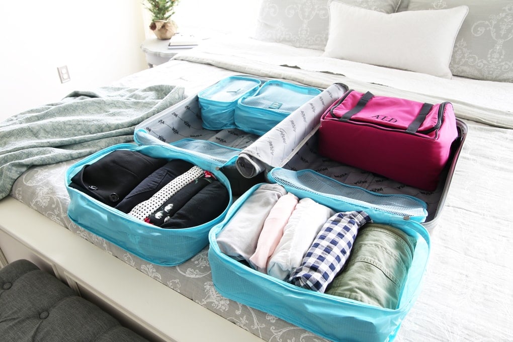 Organized suitcase sitting on top of a bed