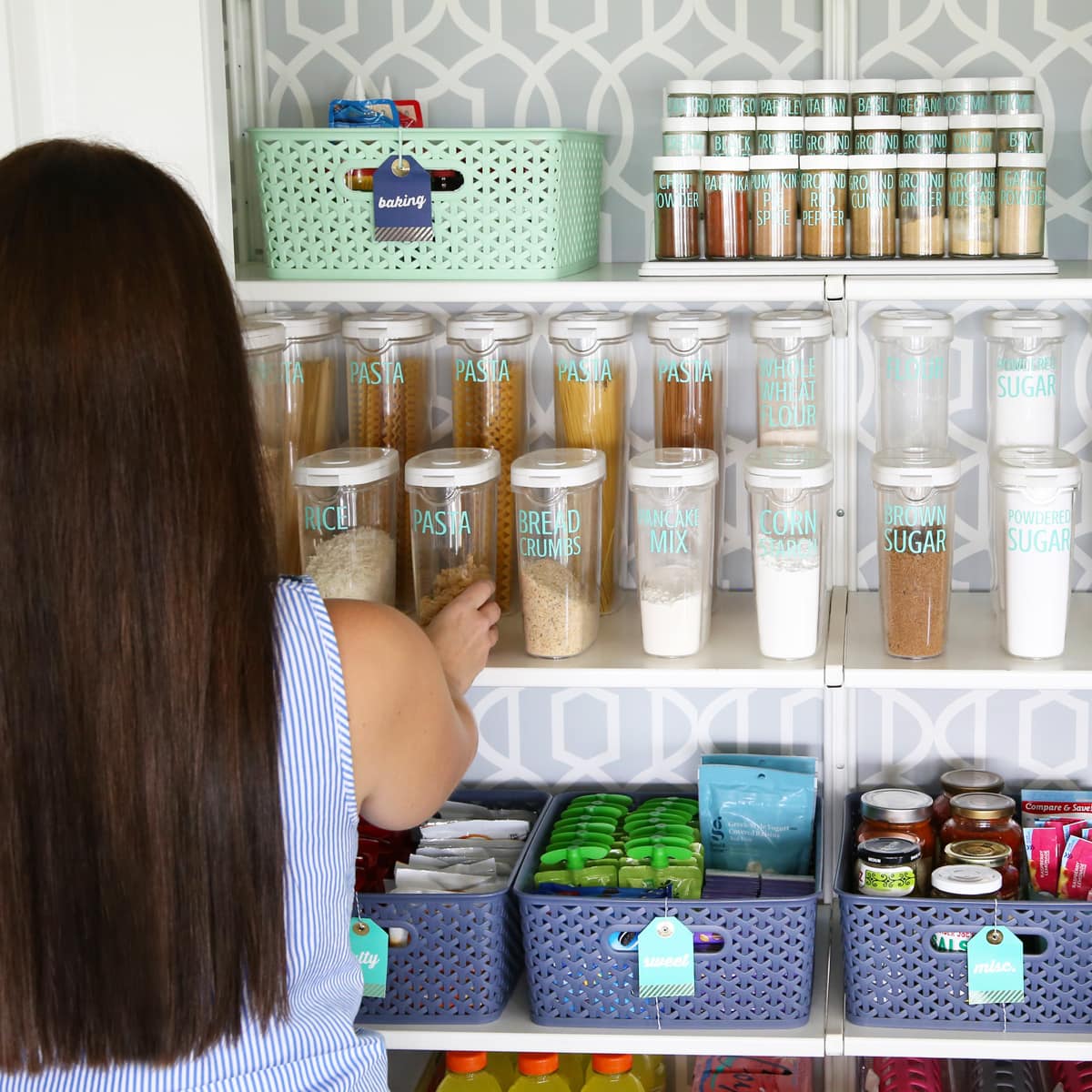 woman with long brown hair reaching into an organized pantry