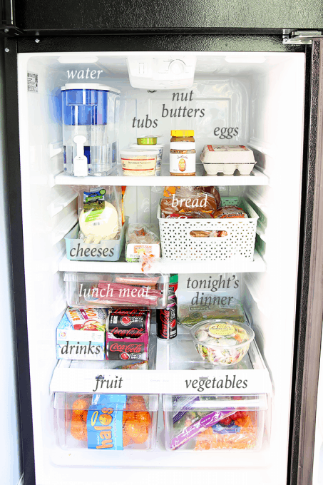 a small organized fridge with text overlay showing the food labeled